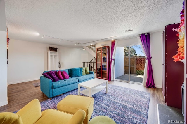 2917 S Locust St, Denver, CO 80222 - living area with wood finished floors, stairway, baseboards, and a textured ceiling