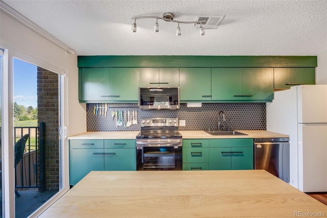 2917 S Locust St, Denver, CO 80222 - kitchen with appliances with stainless steel finishes, a sink, tasteful backsplash, a textured ceiling, and green cabinetry