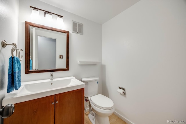 2917 S Locust St, Denver, CO 80222 - half bath featuring toilet, vanity, baseboards, and wood finished floors