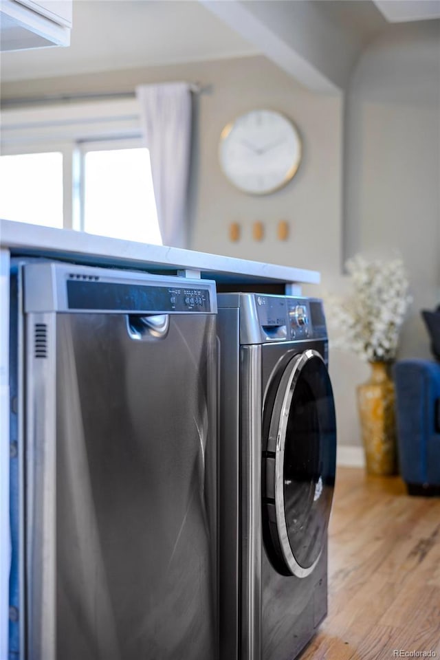 laundry room with laundry area, washer / clothes dryer, and light wood-style floors