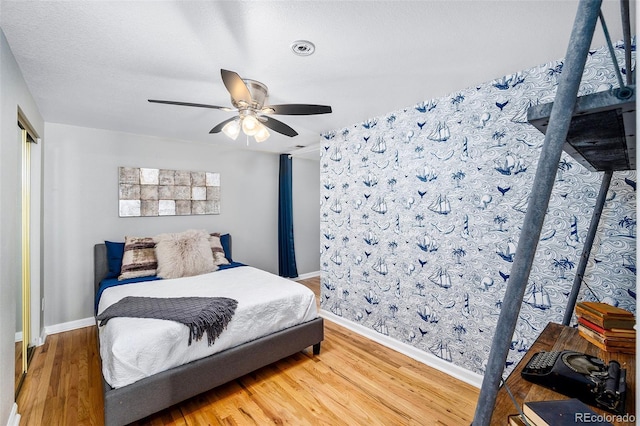 bedroom with ceiling fan, baseboards, and wood finished floors