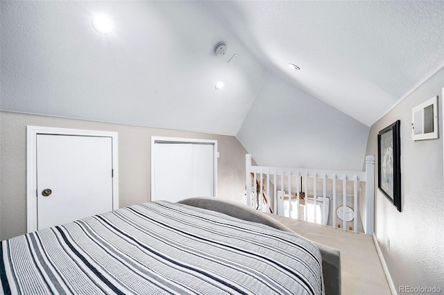 carpeted bedroom with lofted ceiling and a textured ceiling