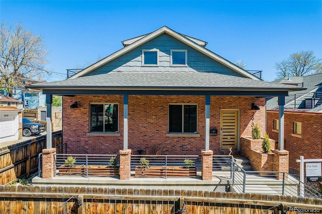 2931 W 20th Ave, Denver, CO 80211 - view of front of house featuring brick siding, a shingled roof, covered porch, fence, and a balcony