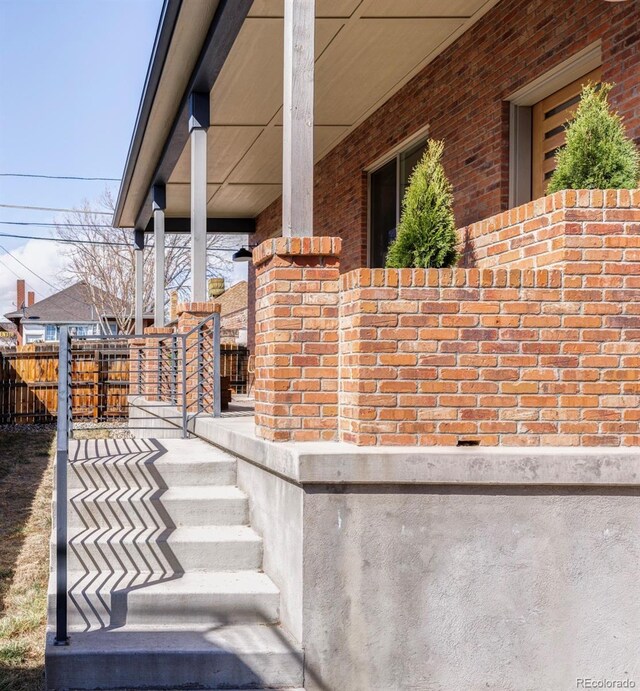 2931 W 20th Ave, Denver, CO 80211 - view of property exterior featuring covered porch, brick siding, and fence