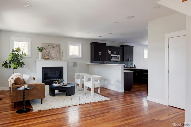 2931 W 20th Ave, Denver, CO 80211 - living room with plenty of natural light, light wood-type flooring, a glass covered fireplace, recessed lighting, and baseboards