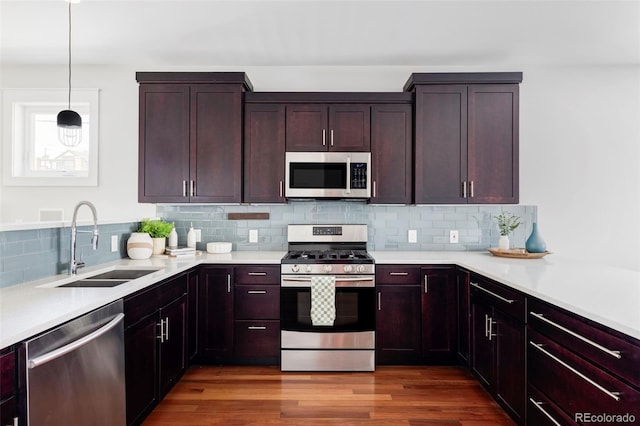 2931 W 20th Ave, Denver, CO 80211 - kitchen with appliances with stainless steel finishes, a sink, decorative backsplash, light countertops, and dark wood-type flooring