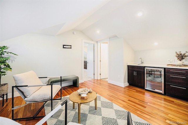 2931 W 20th Ave, Denver, CO 80211 - living room featuring beverage cooler, wet bar, vaulted ceiling, baseboards, and light wood-style flooring