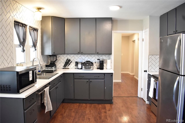 1320 S Lemay Ave, Fort Collins, CO 80524 - kitchen featuring stainless steel appliances, a sink, gray cabinetry, decorative backsplash, and dark wood-type flooring