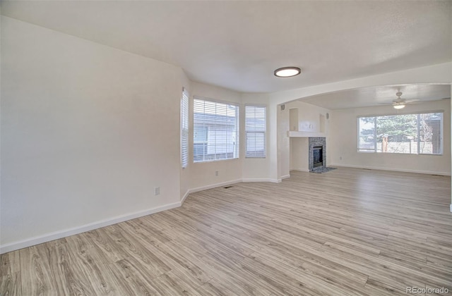 unfurnished living room featuring light hardwood / wood-style flooring, plenty of natural light, and ceiling fan