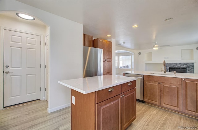 kitchen featuring appliances with stainless steel finishes, sink, a kitchen island, and light wood-type flooring