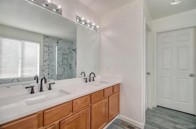 bathroom with walk in shower, vanity, and hardwood / wood-style flooring