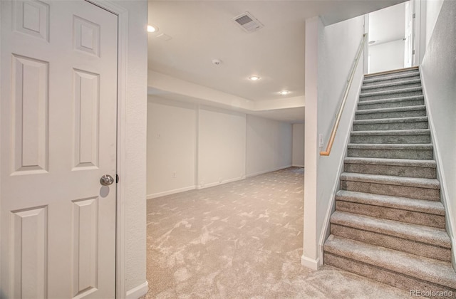 staircase featuring carpet