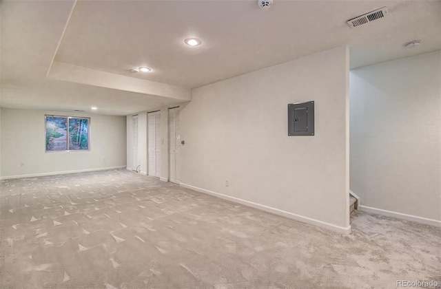 basement featuring light colored carpet and electric panel