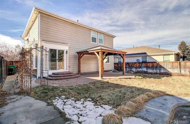 rear view of house featuring a gazebo, a lawn, and a patio