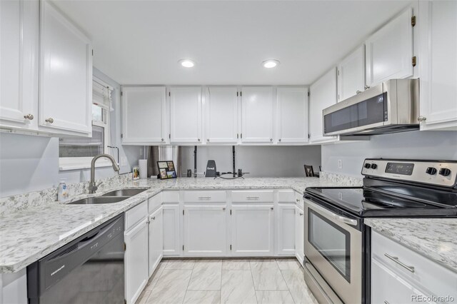 kitchen featuring a sink, light stone counters, recessed lighting, appliances with stainless steel finishes, and white cabinets