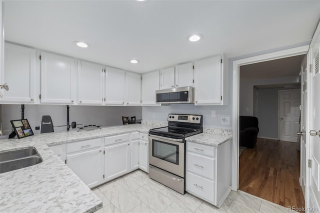 kitchen featuring white cabinetry, recessed lighting, light stone countertops, and stainless steel appliances