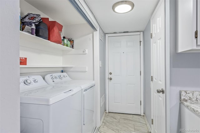 clothes washing area featuring marble finish floor, laundry area, and washing machine and clothes dryer