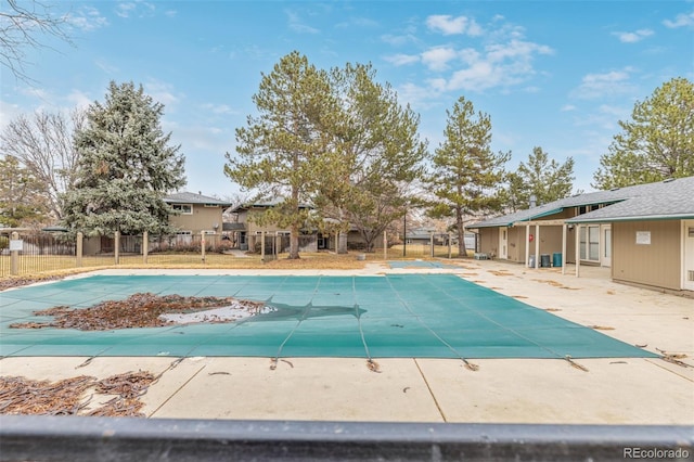 pool with a patio area and fence