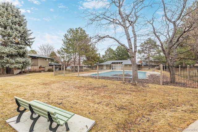 view of yard featuring a community pool and a fenced backyard