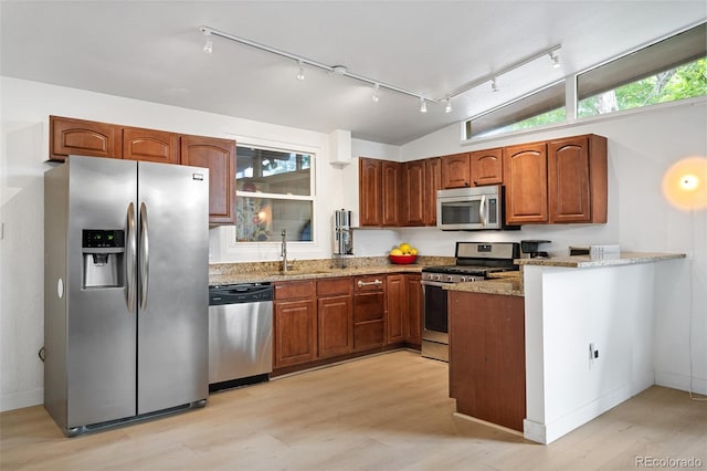 491 Campo St, Denver, CO 80221 - kitchen featuring appliances with stainless steel finishes, rail lighting, light wood-style floors, light stone counters, and vaulted ceiling