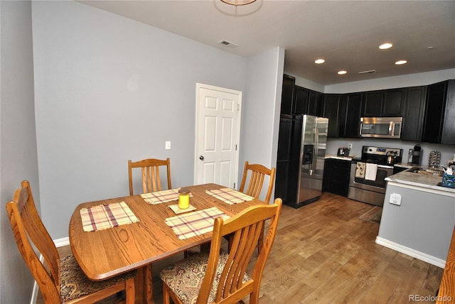 dining room featuring light wood-type flooring, visible vents, and recessed lighting