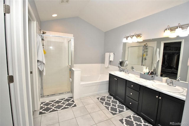 full bathroom with a stall shower, tile patterned flooring, vaulted ceiling, a walk in closet, and a sink