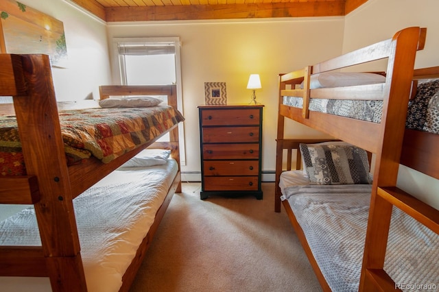 carpeted bedroom with wooden ceiling and a baseboard radiator