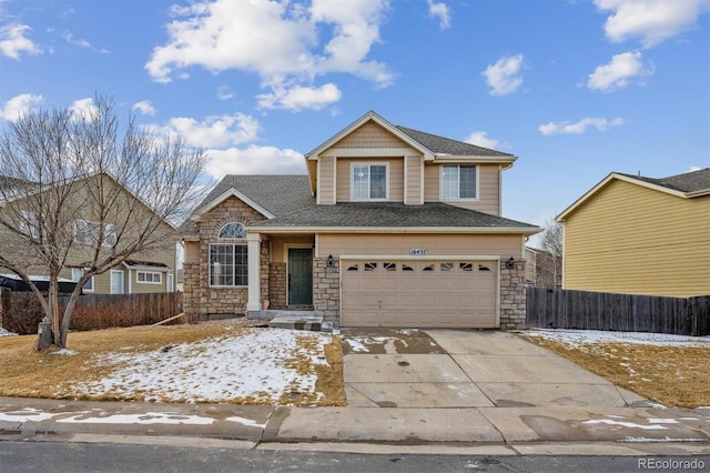 traditional-style home with driveway, stone siding, a garage, and fence