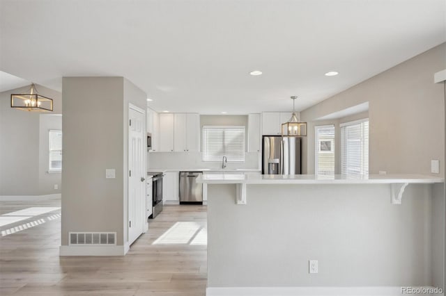 kitchen featuring a notable chandelier, light countertops, visible vents, appliances with stainless steel finishes, and white cabinets