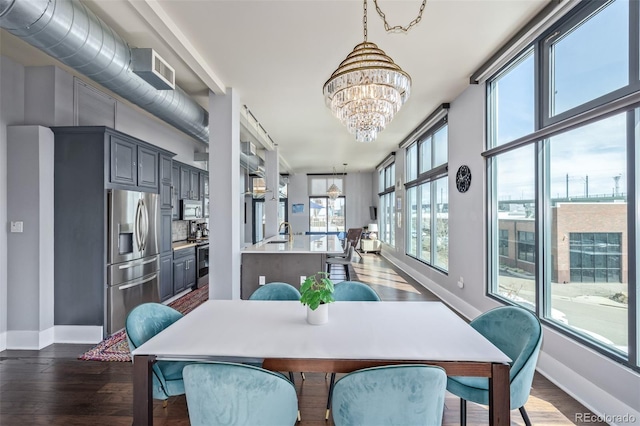 dining space featuring an inviting chandelier, baseboards, dark wood finished floors, and visible vents