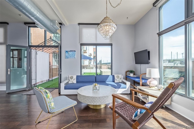 sitting room featuring an inviting chandelier, baseboards, and wood finished floors