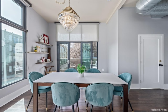 dining space featuring baseboards, dark wood finished floors, and a notable chandelier