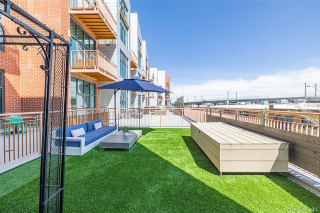 view of yard featuring an outdoor living space, fence, and a balcony
