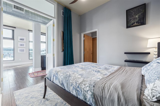 bedroom with visible vents, baseboards, and wood finished floors