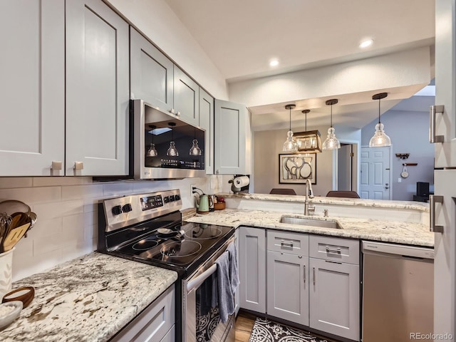 8680 Allison St Unit O, Arvada, CO 80005 - kitchen with stainless steel appliances, decorative backsplash, pendant lighting, light stone counters, and recessed lighting