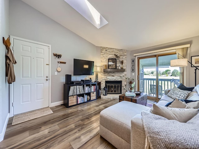 8680 Allison St Unit O, Arvada, CO 80005 - living area featuring vaulted ceiling, wood finished floors, a fireplace, and a skylight