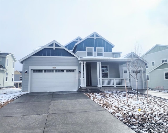 view of front of house with an attached garage, covered porch, board and batten siding, and driveway