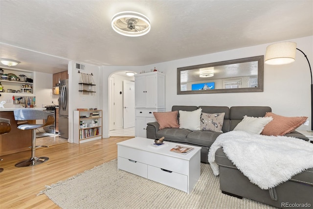 living room with a textured ceiling and light hardwood / wood-style flooring