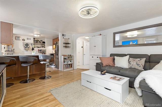 living room with light hardwood / wood-style flooring and a textured ceiling