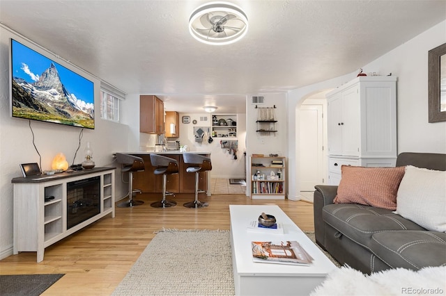 living room featuring a textured ceiling and light hardwood / wood-style floors