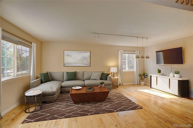 living area with baseboards and wood finished floors