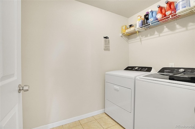 laundry area with laundry area, independent washer and dryer, baseboards, and light tile patterned floors