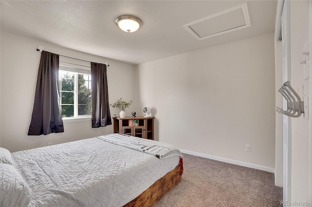 bedroom with attic access, carpet flooring, a textured ceiling, and baseboards