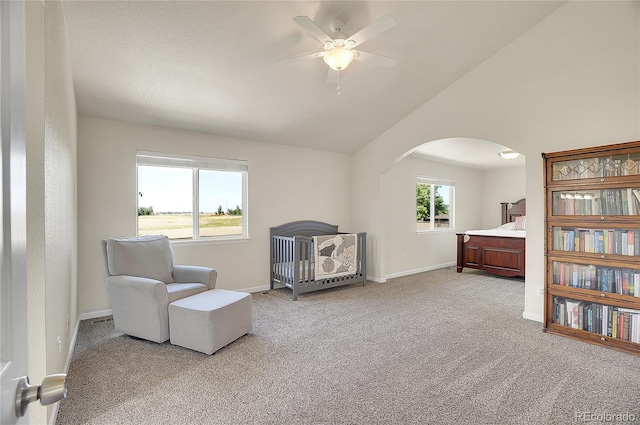 living area with vaulted ceiling, light carpet, baseboards, and a healthy amount of sunlight