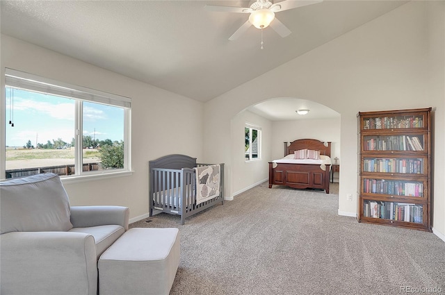 bedroom featuring arched walkways, carpet flooring, vaulted ceiling, and multiple windows