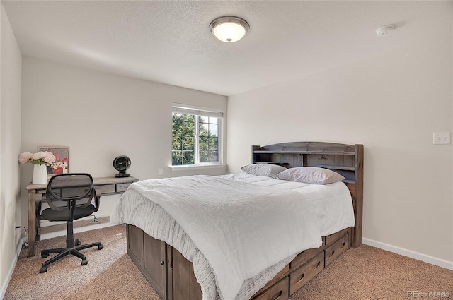 bedroom with baseboards, a textured ceiling, and light colored carpet