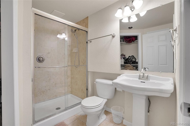 full bath with a stall shower, tile patterned flooring, toilet, and baseboards