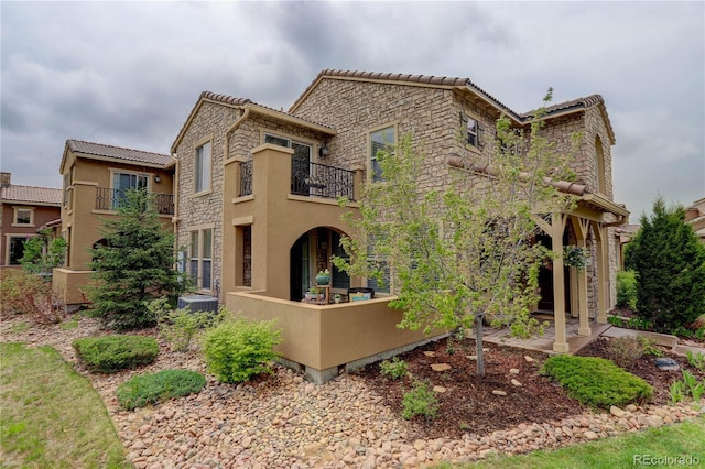 9592 Firenze Way, Highlands Ranch, CO 80126 - view of front of home with a balcony, stone siding, stucco siding, and a tiled roof