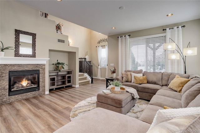 9592 Firenze Way, Highlands Ranch, CO 80126 - living room featuring stairway, light wood-type flooring, a fireplace, baseboards, and recessed lighting