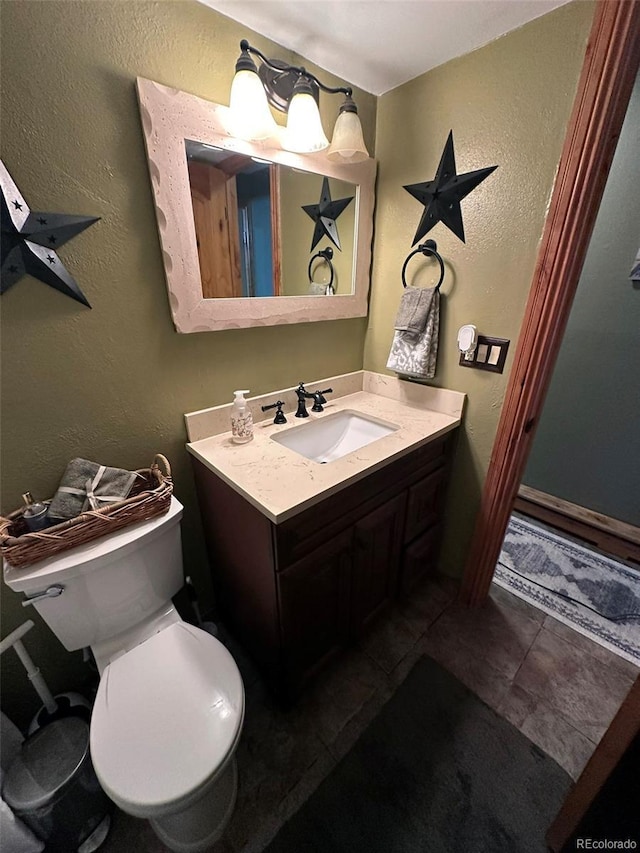 bathroom with tile patterned flooring, vanity, and toilet